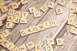 Scrabble pieces spread out on table spelling growth.